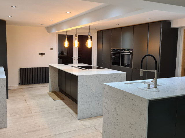 Kitchen with two islands, pendant lights and dark tall units