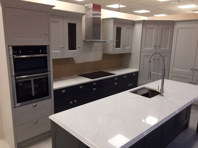 Grey shaker kitchen with dark island and swan-neck tap