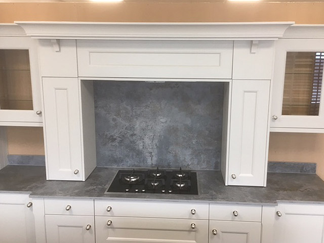 Painted mantle-style cooker surround with stone-look splashback