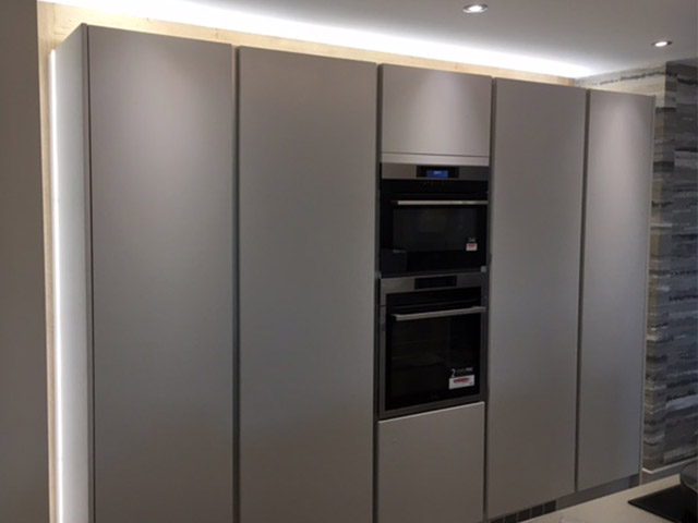 Run of tall handleless units with built-in ovens and lighting