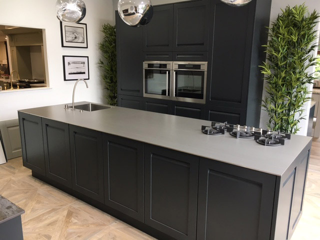 Dark shaker island with tall oven housing behind