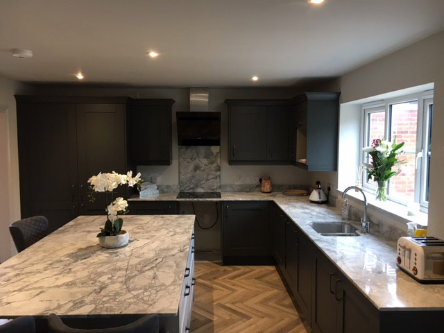 Dark shaker kitchen with marble-look worktops and an island